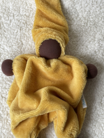 Cuddly doll ocher yellow with dark skin color