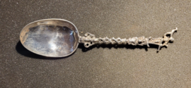 De zilveren lepel heeft een gedeeltelijk bewerkte en getorste steel, waarop aan het einde de vrouw met het anker en de duif.- De Hoop