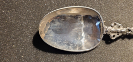 De zilveren lepel heeft een gedeeltelijk bewerkte en getorste steel, waarop aan het einde de vrouw met het anker en de duif.- De Hoop