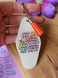 Sleutelhanger met tekst 'BIT OF A  MESS BUT DOIN MY BEST' glow in the dark