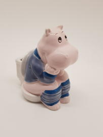 Nilpferd sitzt auf dem Toilettensparschwein