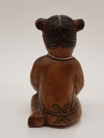 Wooden figurine girl with lucky pendant.