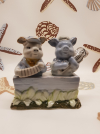 Salz- und Pfefferschweine, Musiker in einem Trog