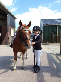 Elena, in een mooie outfit van ons, met haar verzorgpony Kadootje. Haar eerste wedstrijd en gelijk tweede geworden!