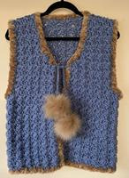 VESTJE MET IMITATIEBONT RANDJE EN POMPONS. BLAUW.