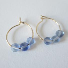 Goudkleurige creolen met blauw steentje.