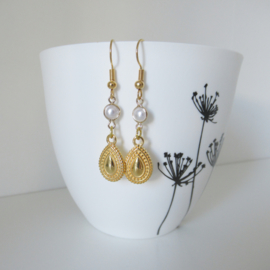 Goudkleurige boho oorbellen met parel bedel