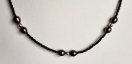 Ketting gevormd uit zwarte kraaltjes met grijze zoetwaterparels