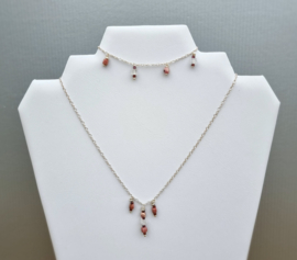 Zilveren ketting met bedeltjes uit rhodoniet en kristal