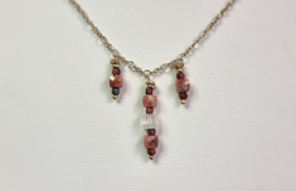 Zilveren ketting met bedeltjes uit rhodoniet en kristal