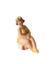 Strandlady zittend op oranje/witte boei - geel