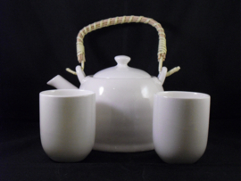 Theepot voor verse thee met kopjes en een zeefje