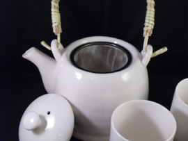 Theepot voor verse thee met kopjes en een zeefje