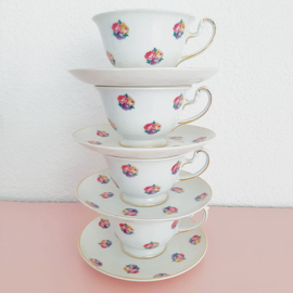 Kopjes en schotels met bloemen