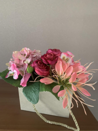 Dik kartonnen tasje gevuld met roze boeketje