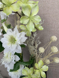 Combinatie van drie groene vazen met witte clematis en groene bloemen