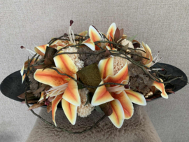 Tafelstuk met oranje lelie's, creme pompons, bruin blad, gouden bes