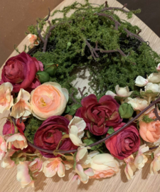 Moskrans met roze ranonkels en bloesem