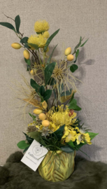 Oker/gele tulpvormige cachepot gevuld met geel/groene tinten