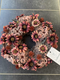 Roze houten krans met mauve chrysantjes, roestbruine bolsters en roze clematis