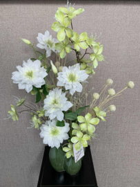 Combinatie van drie groene vazen met witte clematis en groene bloemen