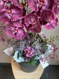 Groot bloemstuk met mauve orchideeen, hortensia en grijze tinten