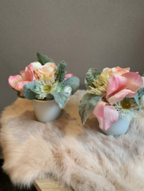 Tafelstukje met roze, witte, grijze tinten in glazen potje