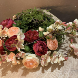 Moskrans met roze ranonkels en bloesem