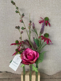 Houten houder met glazen buisjes gevuld met fuschia, bordeaux, paarse tinten