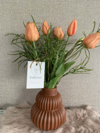 Roestbruine geribbelde vaas met realtouch zalme tulpen en fijn groen
