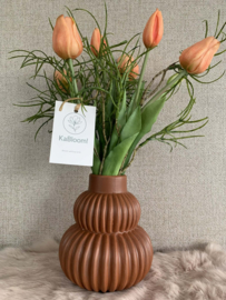 Roestbruine geribbelde vaas met realtouch zalme tulpen en fijn groen