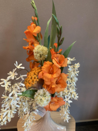 Waaiervormige creme vaas met oranje gladiolen en beige tinten