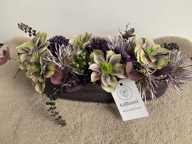 Tafelstuk met groen, paarse helleboris en mauve pompons