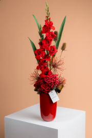 Bloemstuk met rode gladiolen en rode rozen