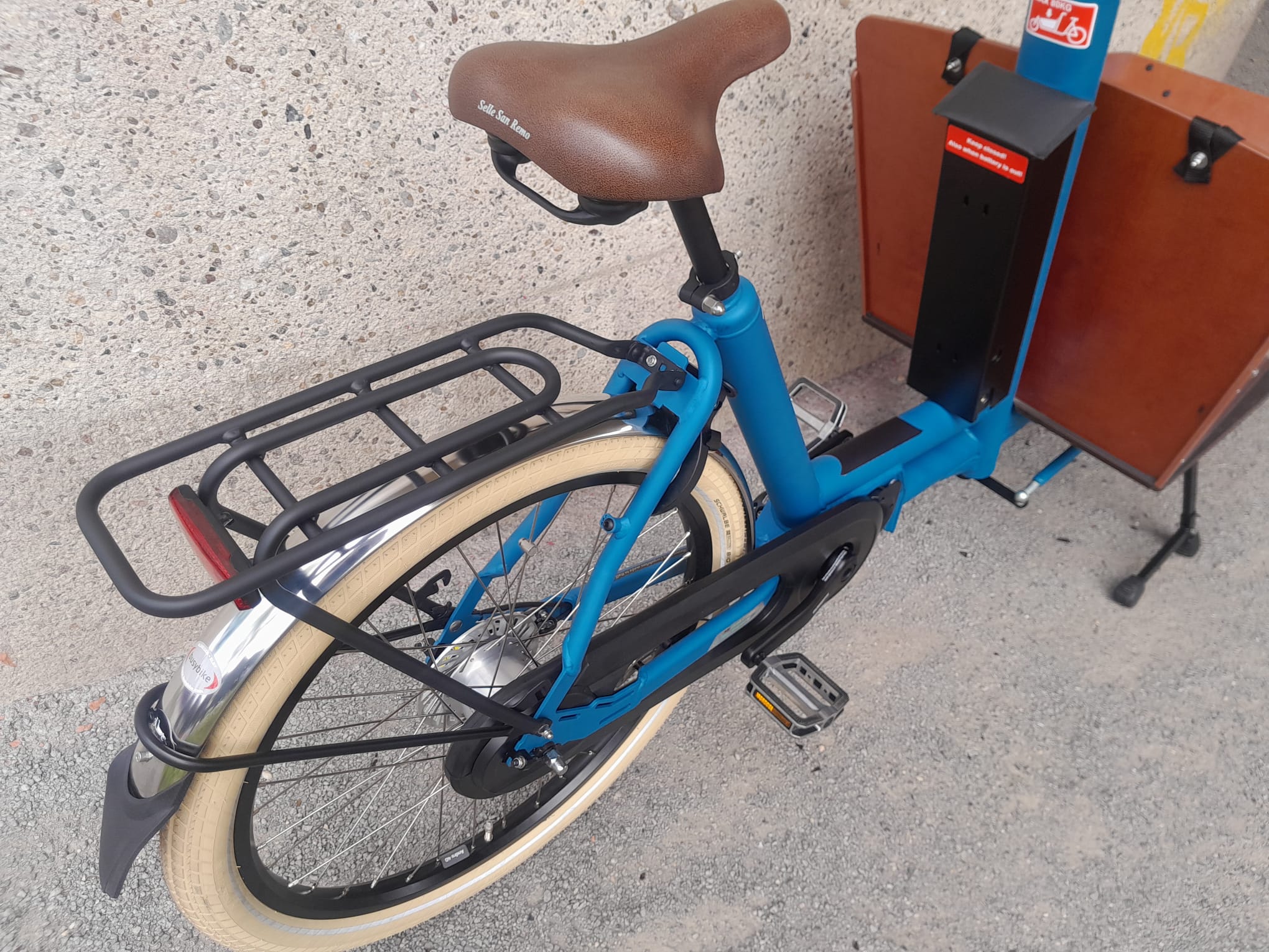Bakfiets.nl Cruiser Short, Mat Petrol Blue, Shimano 5-speed naaf, Rollerbrake remmen, Shimano 6100 middenmotor,  Accu 418Wh, zwarte koplamp, Bruin e-bike zadel, rvs spatborden, zwarte achterdrager