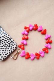 Roze en rode hartjes telefoon armband
