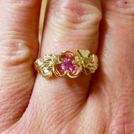 Golden engagement ring with flower, pink sapphire, oak leaf and a butterfly.
