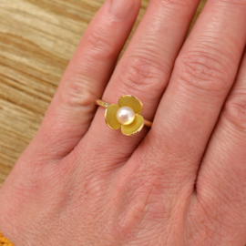 "Honing zoet." Gouden ring met bloem en met parel.