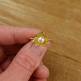 "Honing zoet." Gouden ring met bloem en met parel.