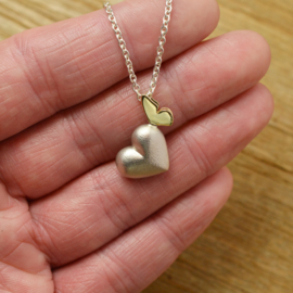 Silver heart with golden butterfly.