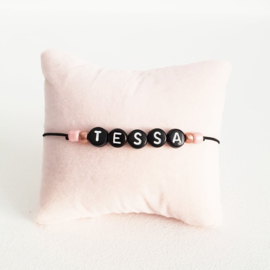 Armbandje zwart elastiek + zwarte kraal met witte letter + licht roze en rosé gouden rocaille