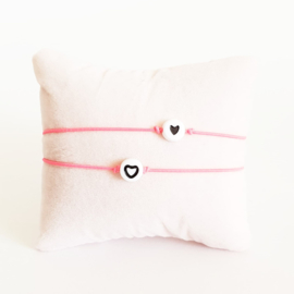 Vriendschapsarmbandjes 2x fluor roze elastiek + witte kraal met zwart hartje